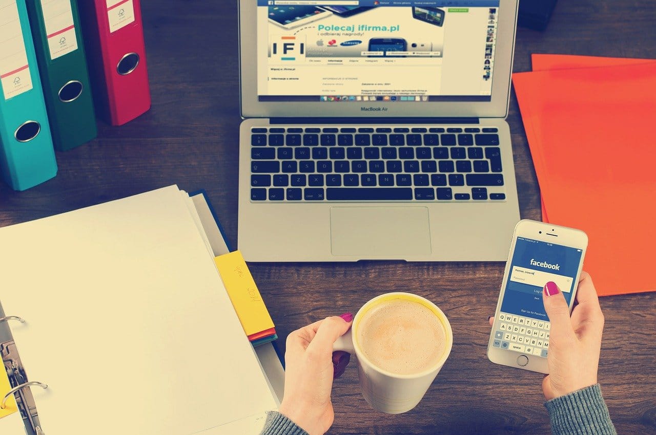 a cup of coffee, a laptop and a smart phone
